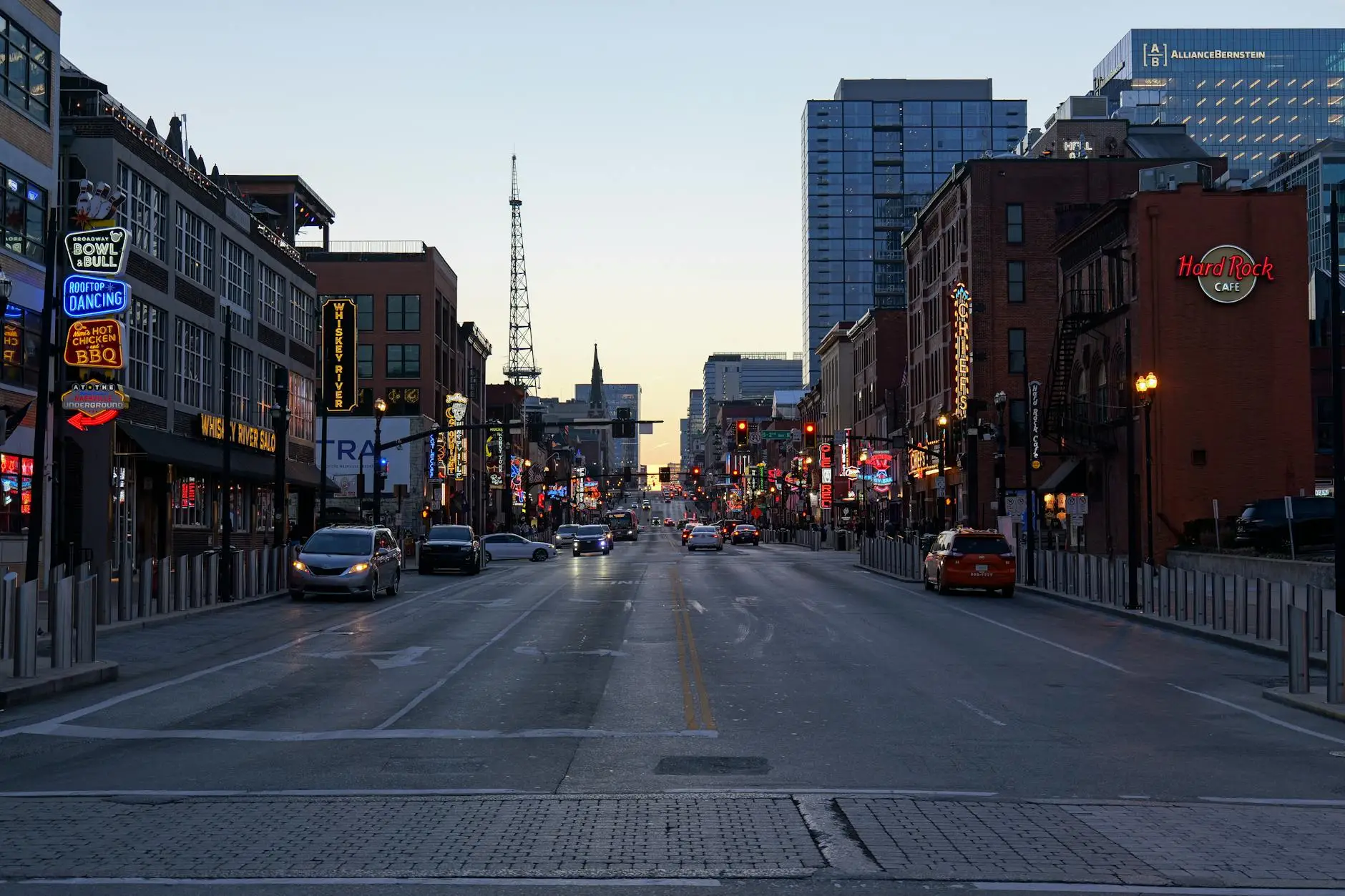 The historic architecture of Lower Broadway in Nashville, featuring neon signs and the Ryman Auditorium in the distance.